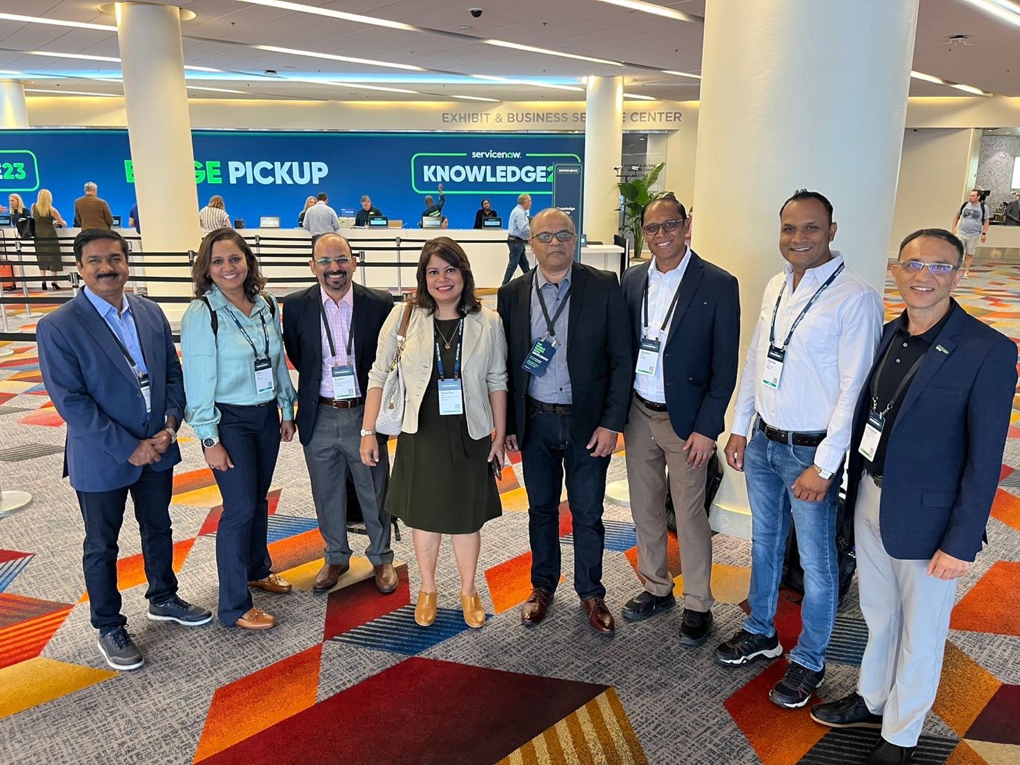 Team InfoBeans standing at Knowledge 2023 venue with other attendees 