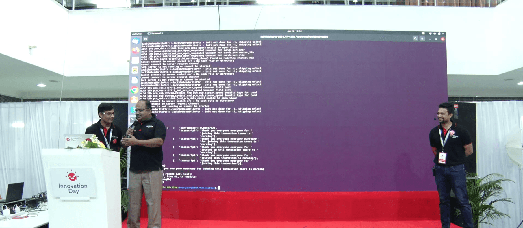 2 members of Team EazeAccent showing a demo of the product on stage.